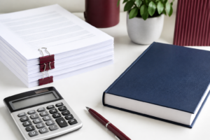 Manuscript, book, and calculator on a desk
